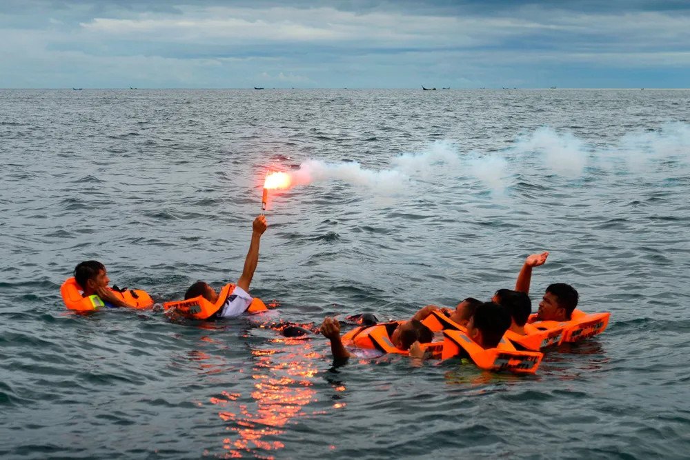 Attention: Drill participants wave a smoke flare for search and rescue teams.