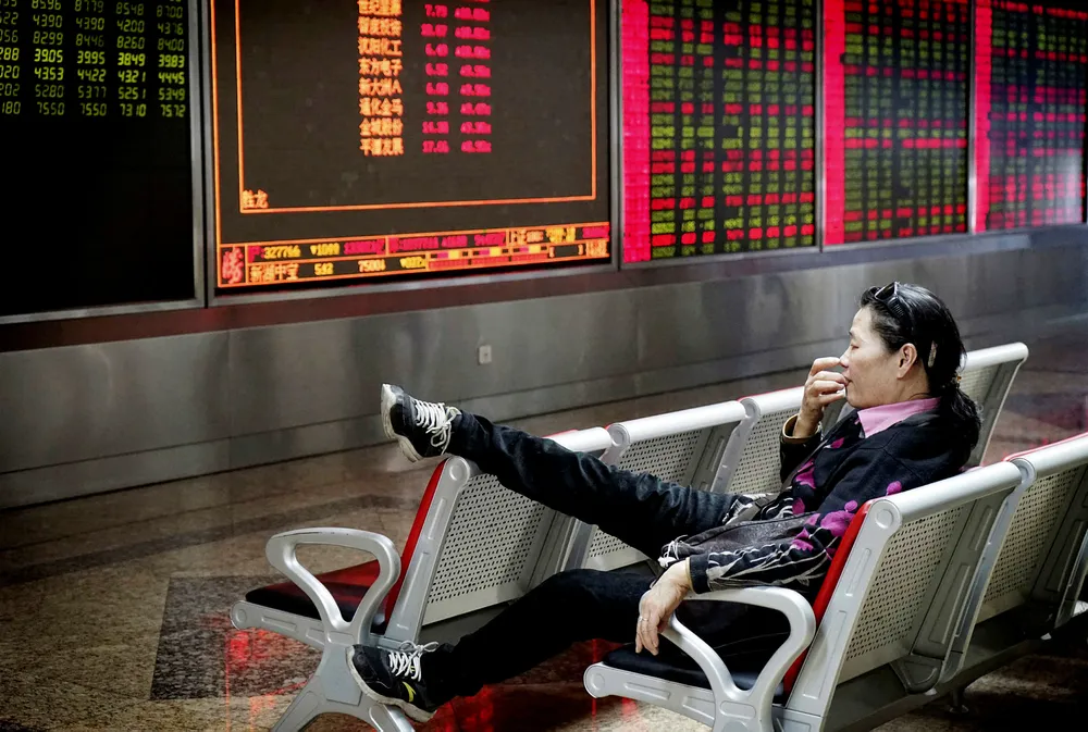 Et stort antall kvinner har skapt egne formuer – uten støtte fra arv eller skilsmisseoppgjør. Bildet viser en investor som følger med på en børstavle i Beijing. Foto: Reuters/NTB scanpix