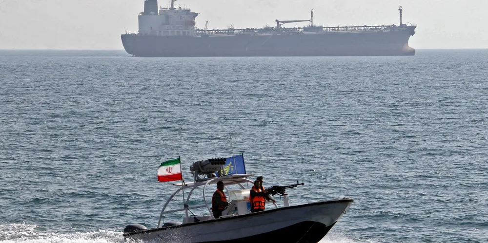 File photo showing an Iranian Revolutionary Guard patrol boat near a commercial ship in the Strait of Hormuz.