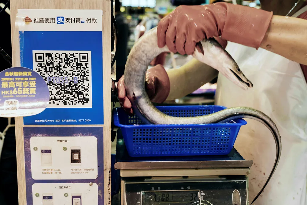 Ant Financials betalingssystem Alipay gjør det mulig å betale med smarttelefon ved flere millioner utsalgssteder i Kina. Her fra et marked i Hong Kong. Foto: Anthony Kwan/Bloomberg