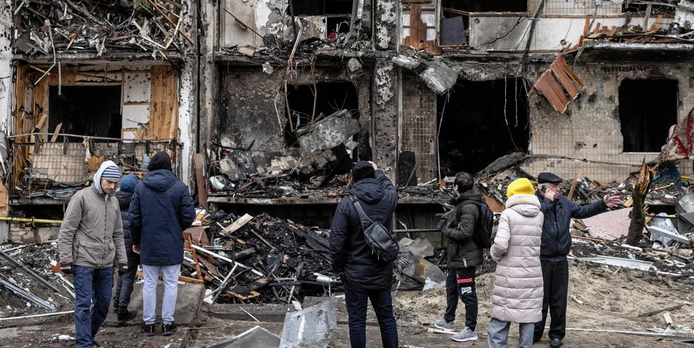 People look at the exterior of a damaged residential block hit by an early morning missile strike on February 25, 2022 in Kyiv, Ukraine