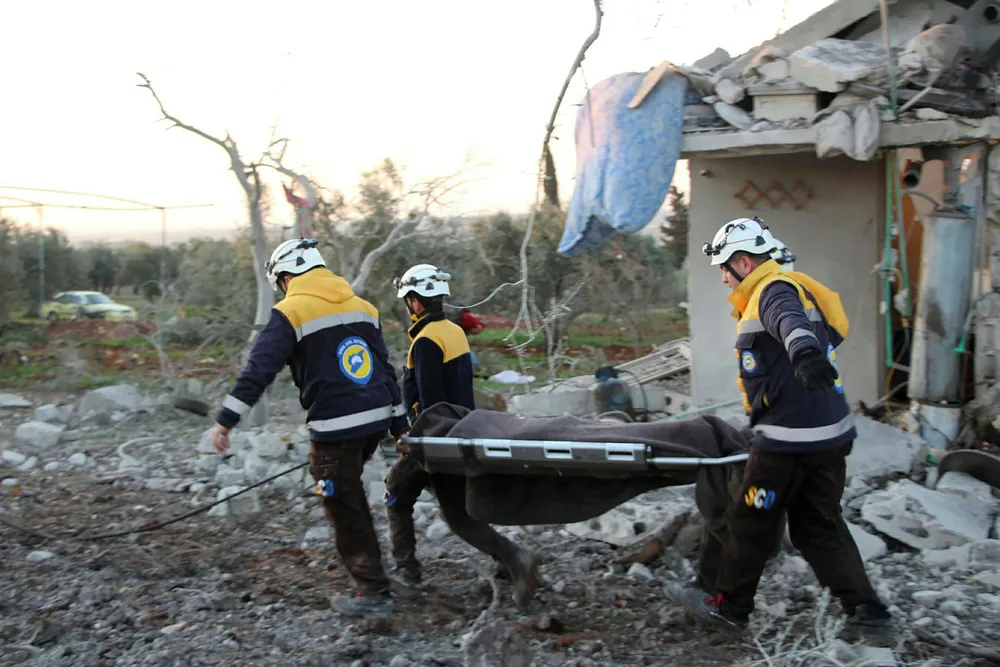 Verdens helseorganisasjon er svært bekymret for at koronaviruset skal spre seg til de krigsherjede områdene i Idlib-regionen hvor rundt tre millioner mennesker er samlet under svært kummerlige forhold. Bildet viser hjelpearbeidere fra sivilforsvarsgruppen De hvite hjelmene som henter ut omkomne etter et flyangrep mot landsbyen Maaret Musreen i Idlib torsdag.