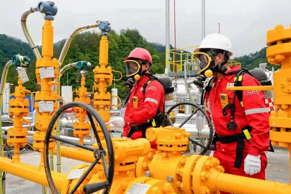 On stream: workers wear gas masks as Tieshanpo sour gas starts to flow.