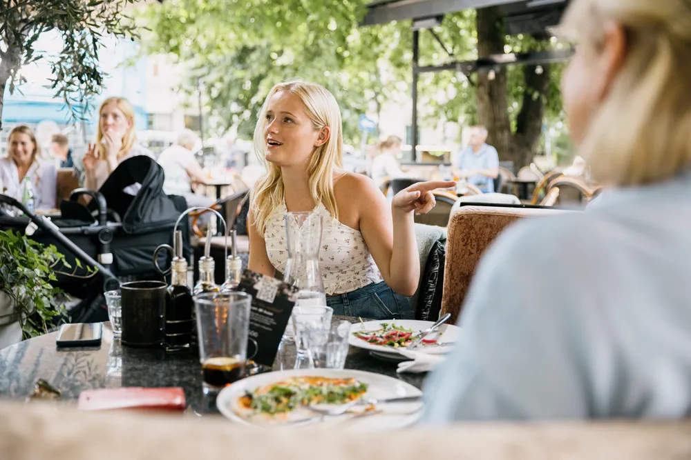 Kortdata viser at folk bruker mindre penger på varer og mer penger på tjenester nå etter gjenåpningen av samfunnet. Julia Sandstø (25) spiser lunsj på Olivia, og har akkurat vært på en 5-ukers tur til USA.