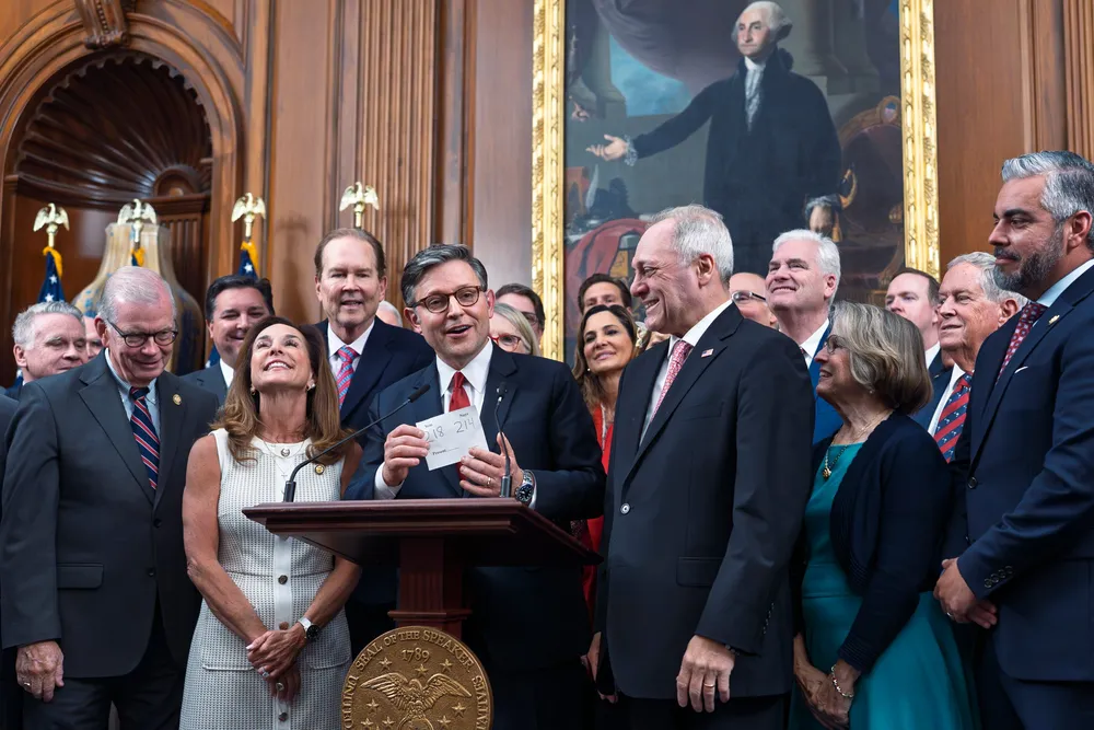 Speaker of the House Mike Johnson, R-La., flanked by Rep. Lisa McClain, R-Mich., left, and Majority Leader Steve Scalise, R-La., right, holds the vote tally sheet as he celebrates with fellow Republicans after final passage of President Donald Trump's signature bill of tax breaks and spending cuts, at the Capitol in Washington, Thursday, 3 July 2025.