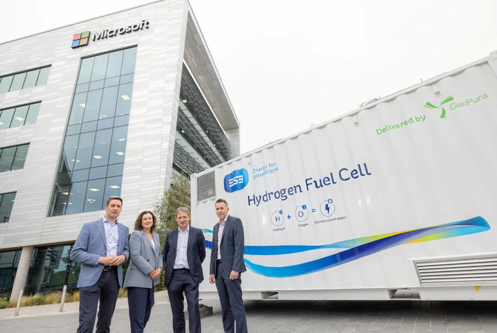 Microsoft and ESB executives standing next to one of ESB's fuel cells in Dublin.