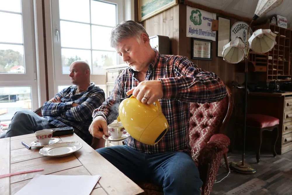 Einar Helge Meløysund serverer kaffe. Ved siden av broren Erlend Johan.