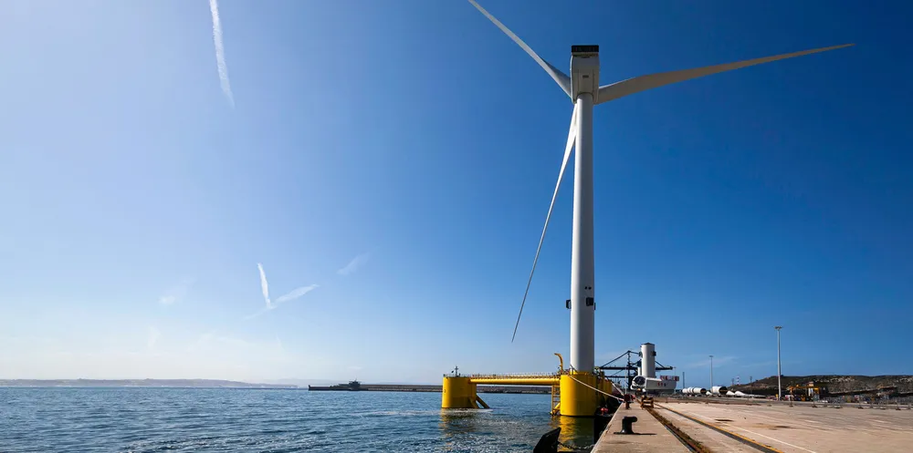 A WindFloat fitted with turbine sits quayside before tow-out to a project site