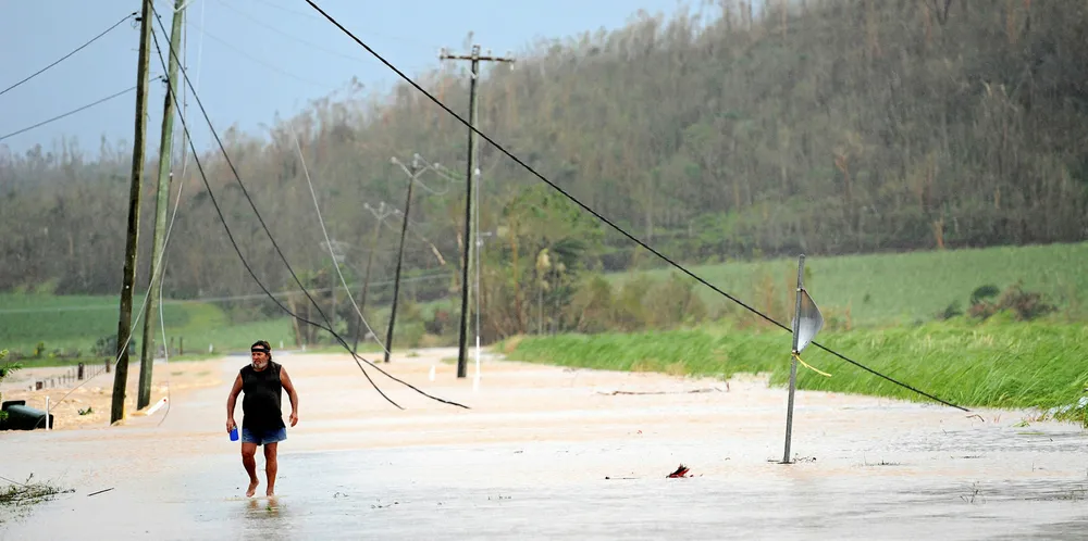 Broken power lines cover a flooded road in Australia. Such damage accounts for almost all outages, said the report.