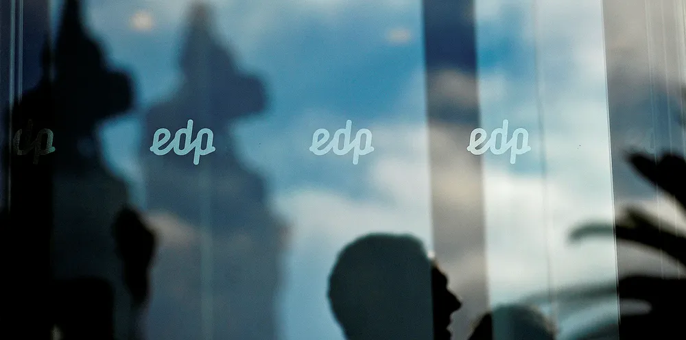 A man's reflection is seen under the EDP (Electricidade De Portugal) logo at the EDP headquarters in Marques do Pombal, Lisbon.