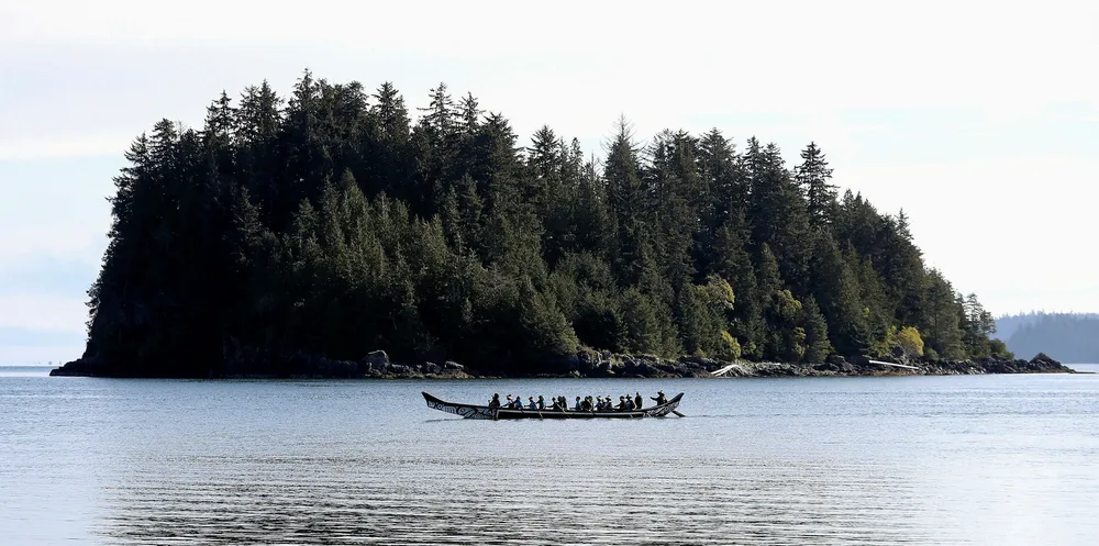 A traditional canoe being paddled at Haida Heritage Centre in Haida Gwaii, off Canada's west coast