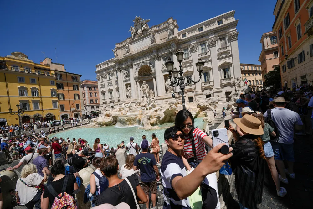 Turister tar en selfie foran Trevifontenen i Roma.