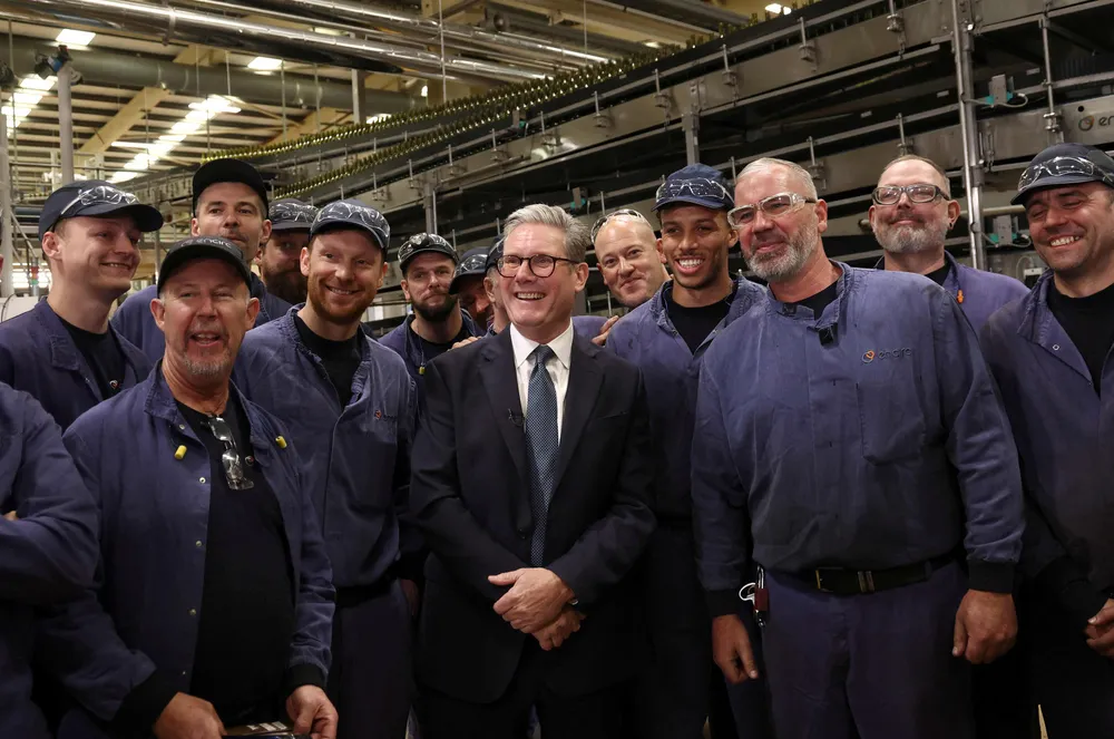 Britain's Prime Minister Keir Starmer poses for a photograph with workers after delivering a speech on green energy at a factory in north-west England on October 4, 2024.