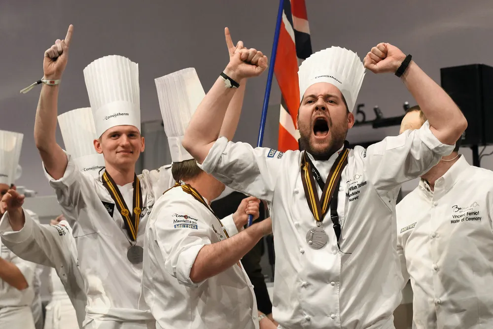 Christopher W. Davidsen (foran) kunne i januar feire sølvmedalje i kokkenes VM, Bocuse d'Or. Nå blir oppgaven å levere kulinariske opplevelser på Britannia Hotel når Odd Reitans totalrenoverte luksushotell åpner i Trondheim i 2019. Foto: Jean-Philippe Ksiazek/AFP/NTB Scanpix