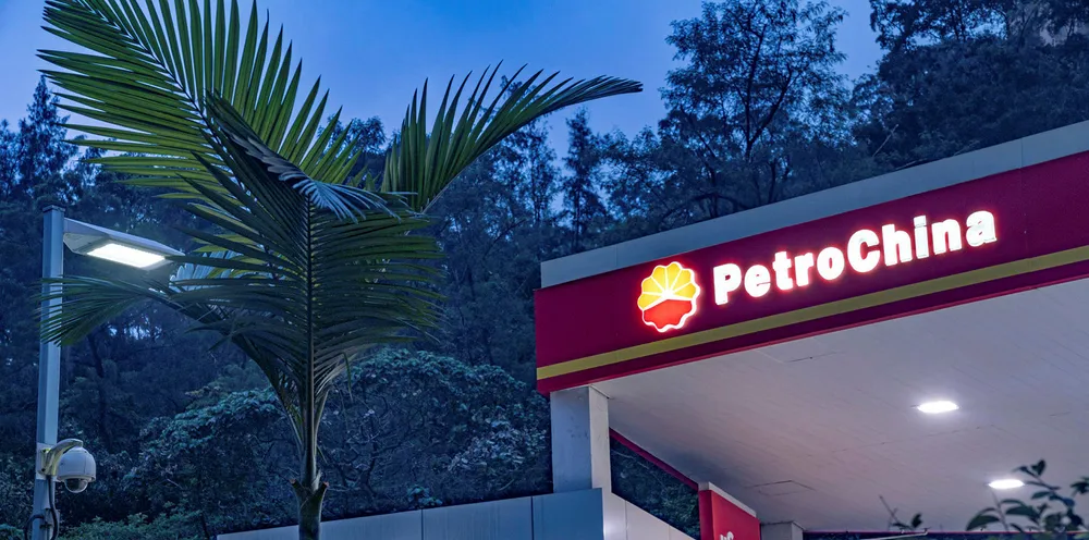 Signage for PetroChina Co. is illuminated atop a gas station at dusk in Hong Kong, China.