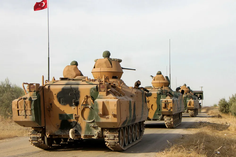 Tyrkiske soldater rykker her frem i pansrede beltevogner nord for byen Manbij i Syria. Det militære eventyret i Syria kan koste Tyrkia dyrt økonomisk.