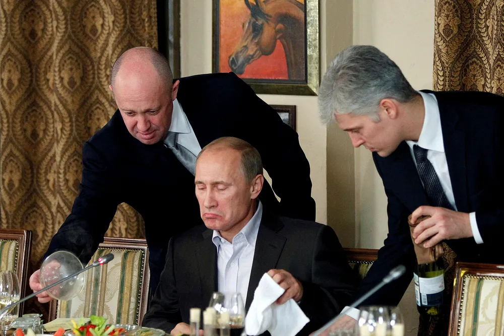 Jevgenij Prigozjin (til venstre) omtales ofte som Vladimir Putins kokk. Her serverer han presidenten på en restaurant i Moskva.