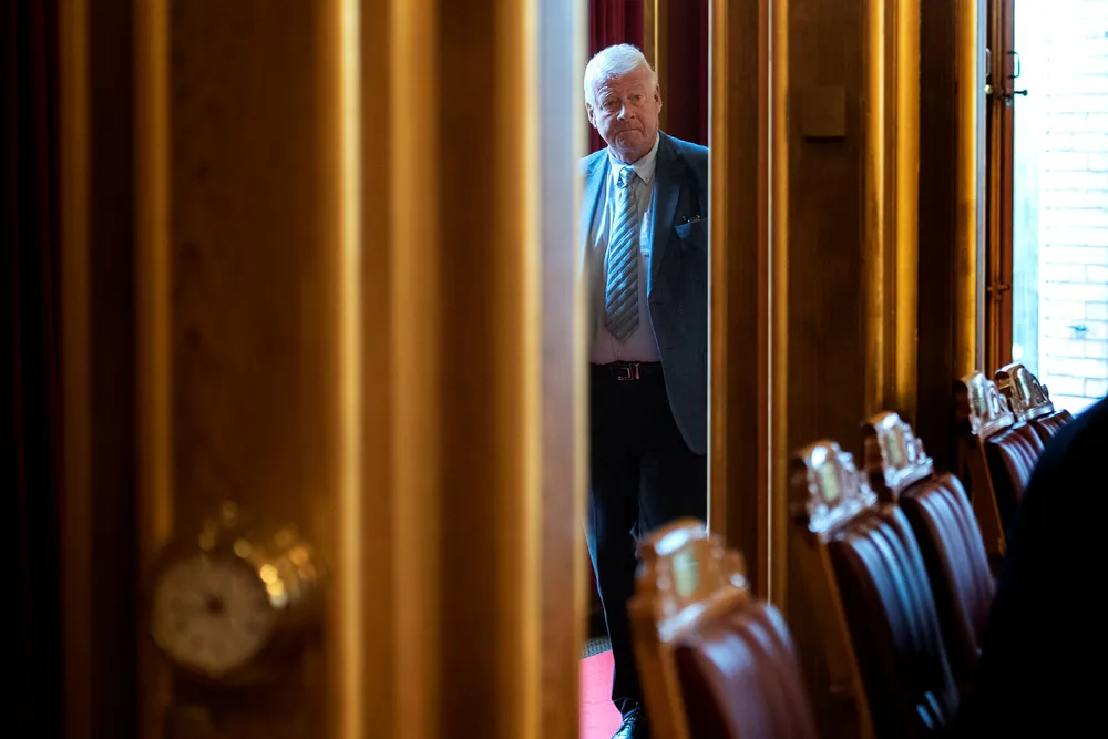 Vararepresentant til Stortinget, Carl I. Hagen, synes lite om kollegene som står bak i salen og prater når det skal voteres. Her er han på vei ut av salen onsdag.
