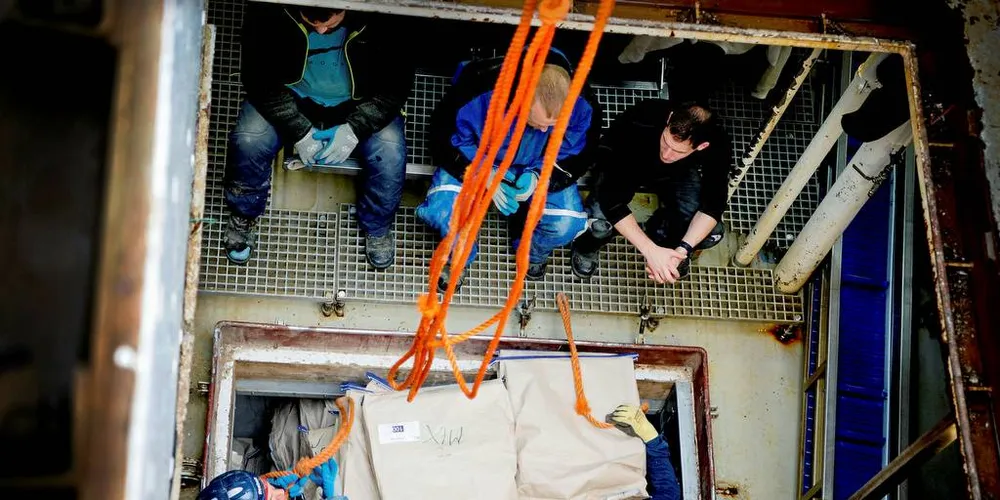 FROSSEN TORSK: Lossere fra Tromsø Ekspresslossing tar opp frossen torsken fra tråleren ved Senjahopen. Foto: Mikaela Berg