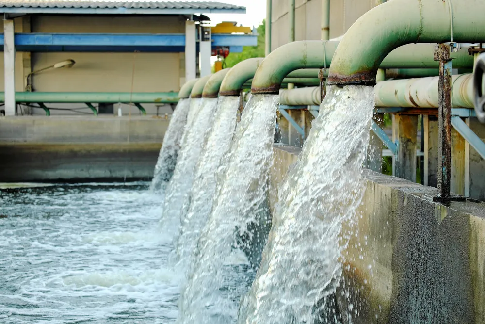 Water flows from a pipe for industrial cooling.