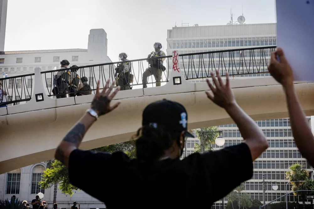 Den amerikanske nasjonalgarden ser ned på demonstranter foran en føderal bygning i sentrum av Los Angeles.