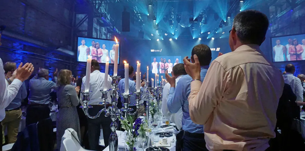 Attendees stand and clap for the Baader family during the company's 100th anniversary.