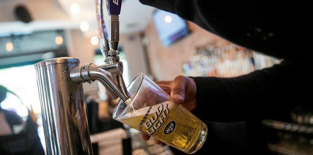 A Bud Light beer is poured from the tap at a bar.