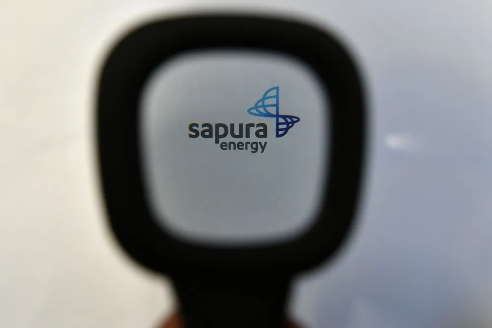 Sapura Energy's logo is seen through a magnifying glass at their headquarters in Kuala Lumpur, Malaysia.