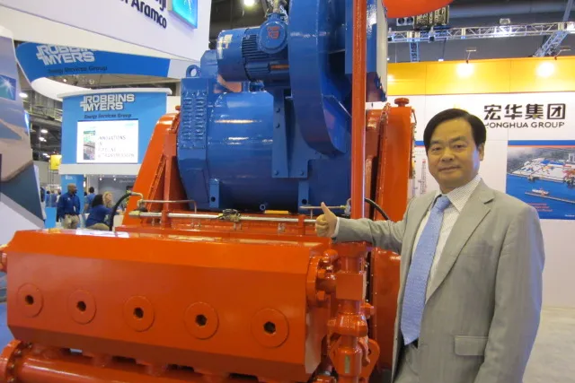 Honghua shale rigs: Company president Zhang Mi shows off fracturing pump from integrated shale drilling system at OTC 2013