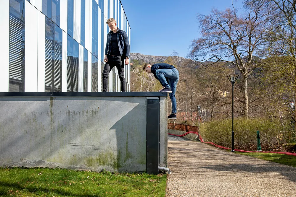 Herman Melbye (23) (til venstre) har utviklet tjenesten UtdanningX som skal gi bedre rådgivning til studenter som skal søke høyere utdannelse. Her med UiB-student Fabian Johnsen (23) som er digitalutvikler i selskapet, på vei opp på et tak på NHH for å bli fotografert.