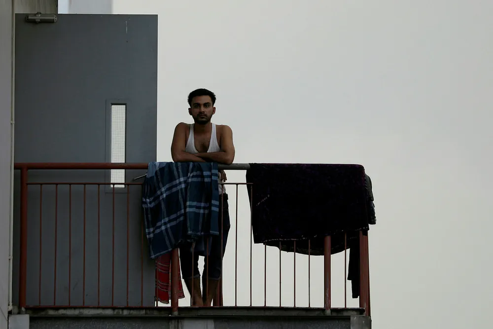 Lockdown: a migrant worker outside his room in a factory-converted dormitory in late May amid the coronavirus pandemic outbreak in Singapore
