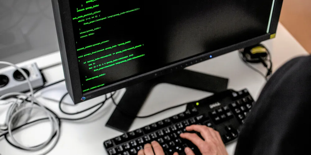 Phishing har vært og er en mye brukt form for svindel, som baserer seg på sosial manipulering for å få folk til å avsløre sensitiv informasjon eller utføre andre skadelige handlinger. Illustrasjonsbilde: Mann som sitter bak datamaskin og hacker.