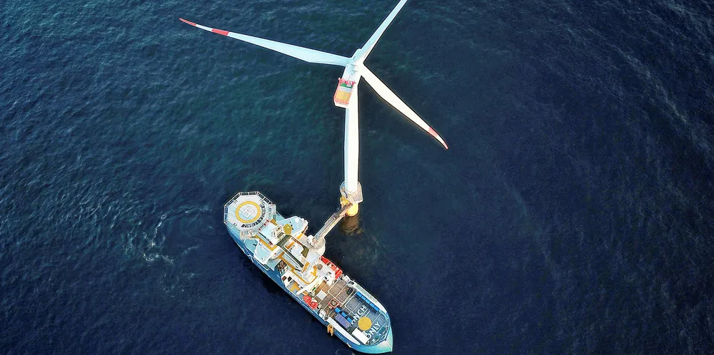 Support vessel with transfer bridge locked onto offshore wind turbine