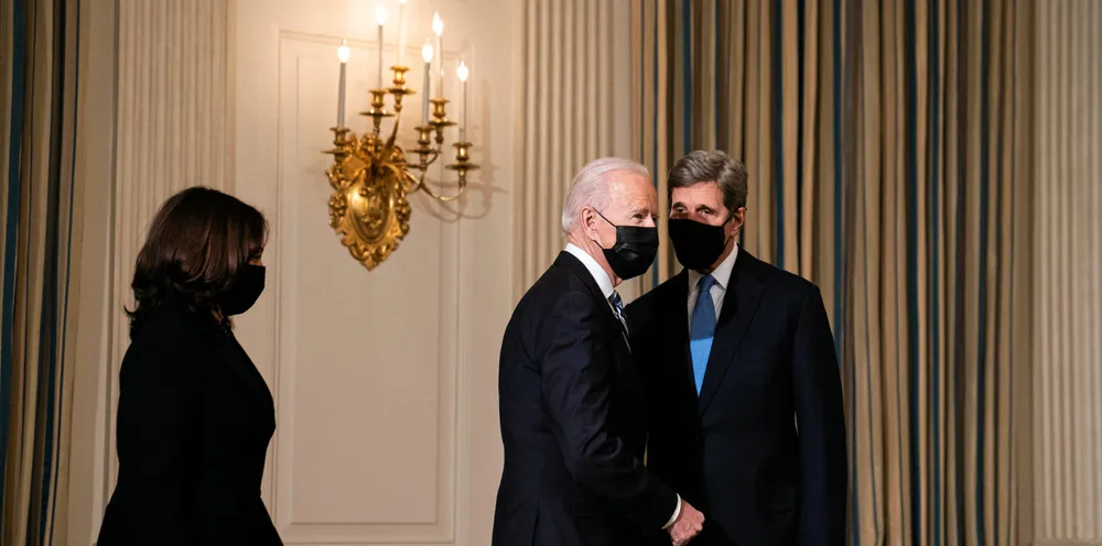 US President Joe Biden greets Special Presidential Envoy for Climate John Kerry as he arrives to speak about climate change issues in the State Dining Room of the White House.
