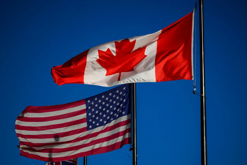 Flaggene til Canada og USA vaiet utenfor et hotell i sentrum av Ottawa lørdag.