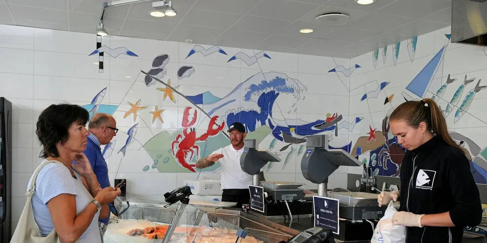 FAVORITTSTED: Jeannette og Totto Wold er innom fiskebutikken til Risør Fiskemottak nesten daglig når de er på hytta. Denne dagen var de så heldige å få rå sjøkreps av Espen Ellefsen og Johanna Lindstøl.Foto: Kjersti Kvile