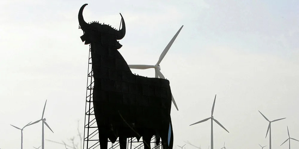 An Osborne bull is by range of windturbines in La Muela near Zaragoza.