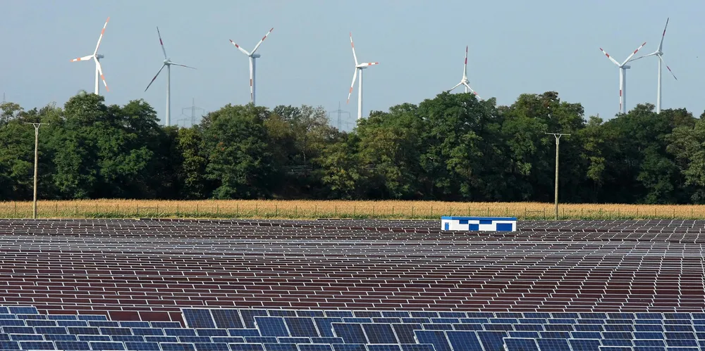 Wind turbines behind a PV farm near the headquarters and production facilities of German solar cell maker Q-Cells