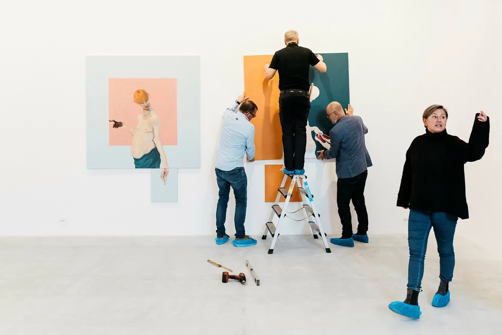 Eli Ertvaag, til høyre, åpner nytt kunstgalleri i Stavanger. I bakgrunnen den danske kunstneren Mikael Kvium, til høyre, i gang med å henge opp verkene sine sammen med Kim Brandstrup, til venstre, og vaktmester Johan Buch. Foto: Tommy Ellingsen