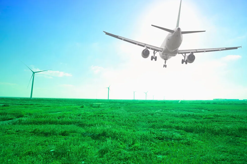 Rendering of an airplane flying over a wind farm.