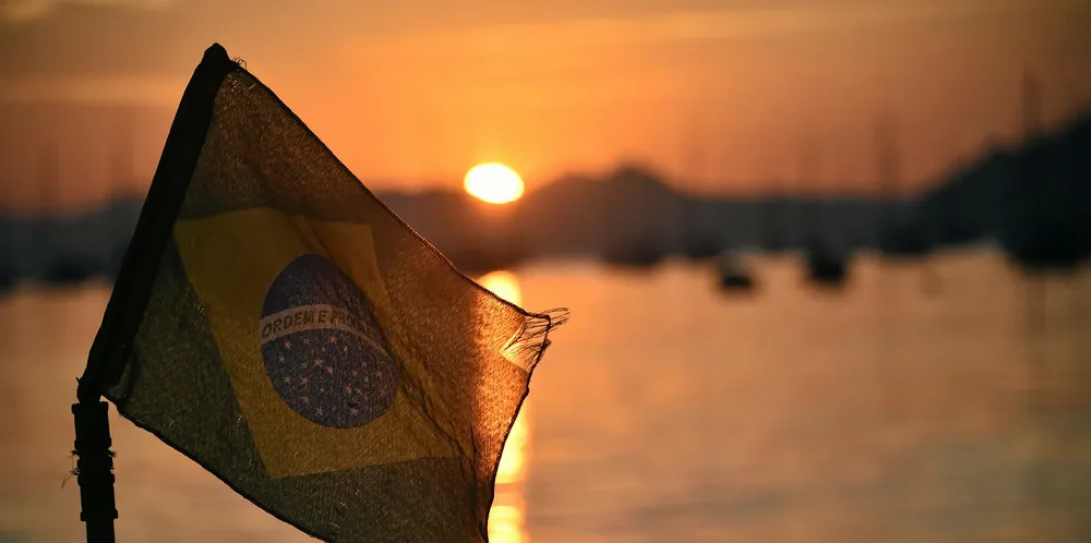 The Brazilian flag flys at sunrise on the Botafojo beach in Rio de Janeiro.