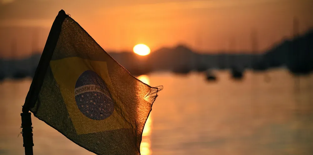 The Brazilian flag flies at sunrise on the Botafojo beach in Rio de Janeiro.