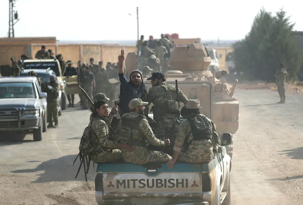 Det kan hende at det siste Syria-trekket til Trump er et forsøk på å gi Iran økt diplomatisk og politisk spillerom slik at veien til forhandlingsbordet med USA blir kortere. Bildet viser syriske opprørere som samles ved grensebyen Tal Abyad, Syria denne uken.