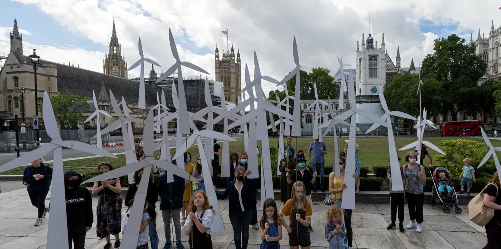 Parents and children hold handmade wind turbines, creating a wind farm, outside Downing Street to call for a green economic recovery after the coronavirus pandemic.