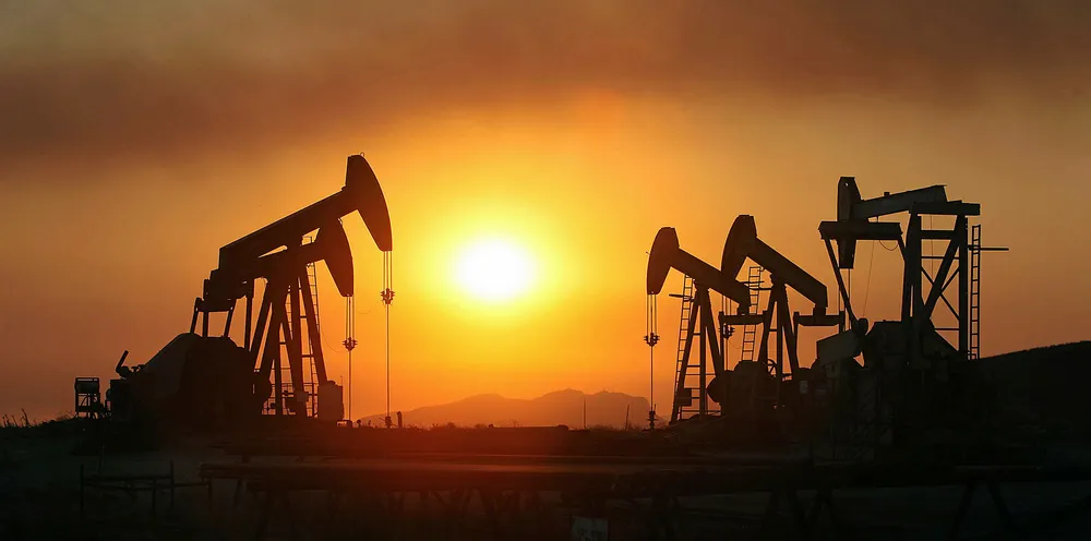 Smoke from a wildfire blows past oil wells in California.