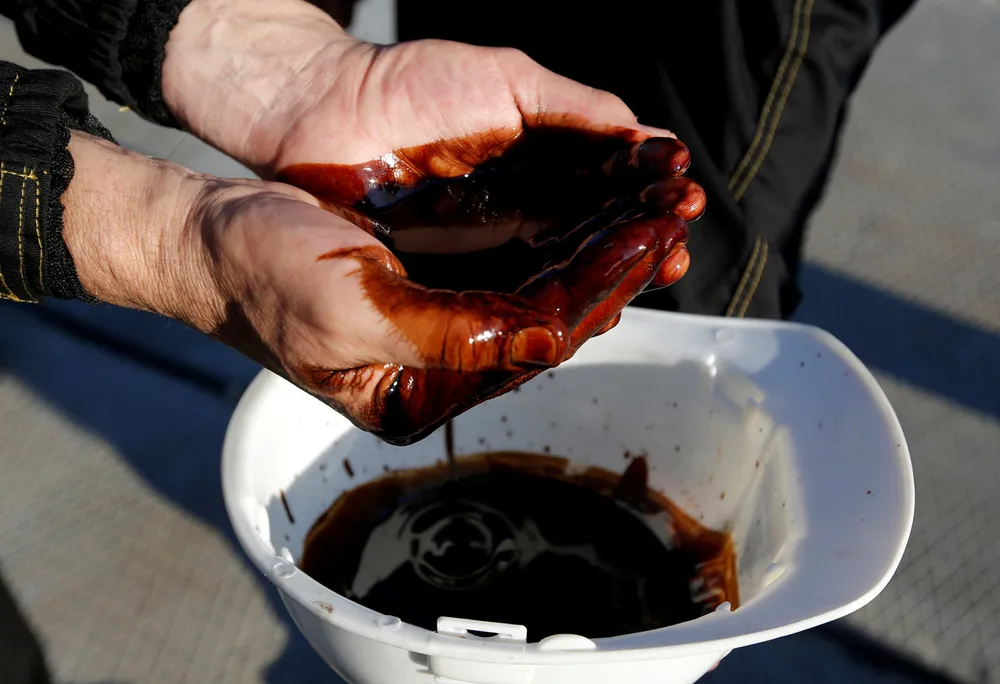 Wanted commodity: employees demonstrate a sample of oil from a well at the Rosneft-operated Priobskoye oilfield in Russia's Khanty-Mansiysk region