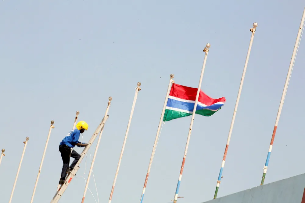 A man fixes Gambia national flag during the preparation of the swearing-in ceremony of Gambia's new President Adama Barrow at Independence Stadium, in Bakau, Gambia February 16, 2017. Picture taken on February 16, 2017.REUTERS/Thierry Gouegnon