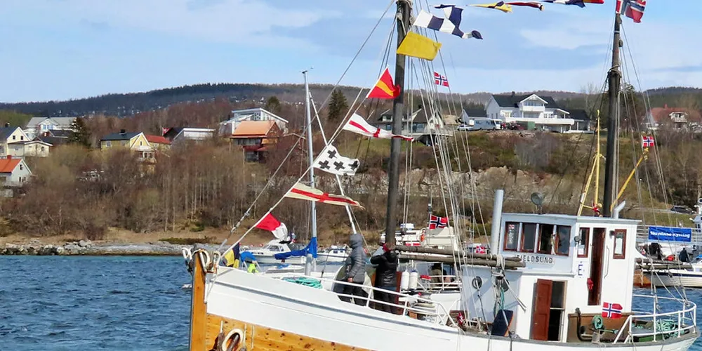 SENTRAL: Veterankutteren «Tjeldsund» hadde som seg hør og bør en sentral plass i 17. mai-konvoien i Tjeldsundet, og er her fotografert da konvoien samlet seg til avslutning utenfor Evenskjer. Lyden av en 30 hk Union bidro til stemningen, selv om rederiet må tåle litt trekk for skjemmende fendring …