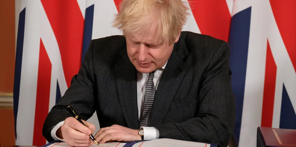 Prime Minister, Boris Johnson signs a page of the Brexit trade deal with the EU in number 10 Downing Street.
