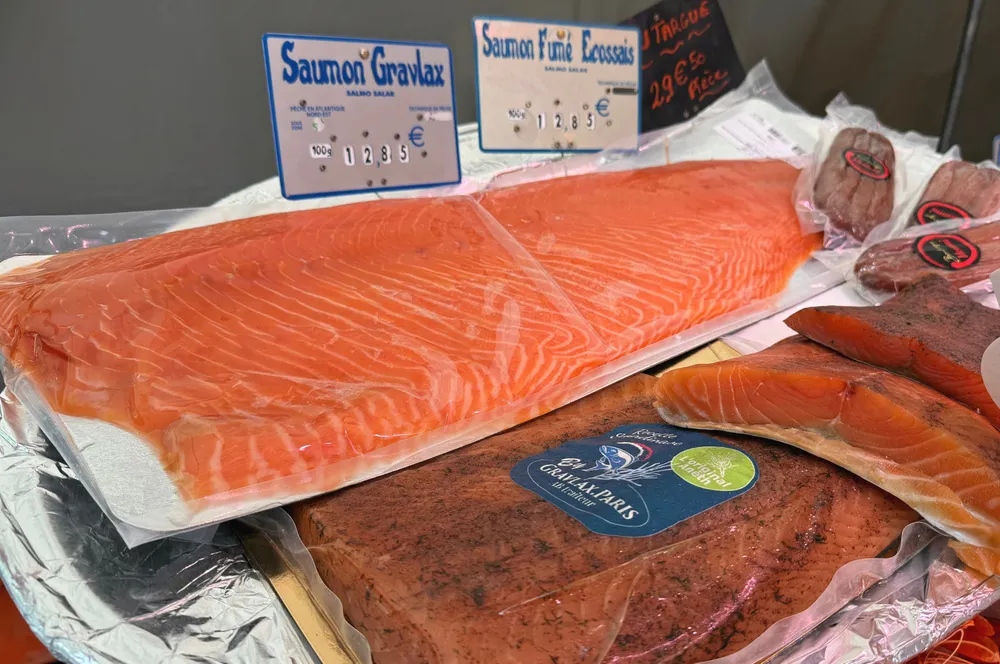 Bearbeidet norsk laks i EU: Norsk gravlaks på fransk maner, her i konkurranse i fiskedisken med røkt skotsk laks. Fra marked i Paris. Juni 2024.